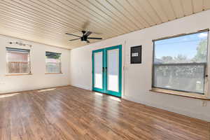 Empty room featuring wood finished floors, wood ceiling, ceiling fan, and french doors