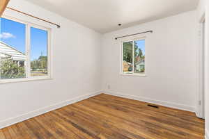 Empty room with wood-type flooring and baseboards