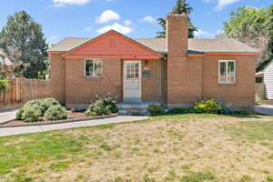 Bungalow with a chimney, brick siding, and a shingled roof