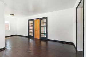 Empty room with dark wood-style floors and baseboards