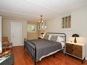 Bedroom with wood finished floors and a chandelier