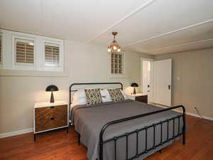 Bedroom featuring wood finished floors and a chandelier