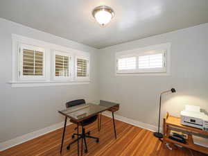 Office area with baseboards and wood finished floors