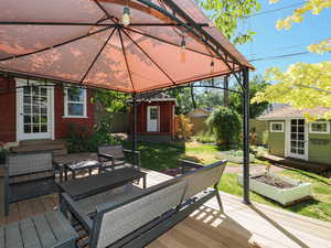 Wooden deck featuring a garden and a storage unit
