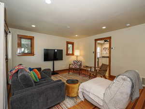 Living room with wood finished floors, recessed lighting, and ceiling fan