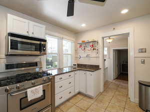 Kitchen featuring stainless steel appliances, white cabinetry, healthy amount of natural light, light tile patterned flooring, and recessed lighting