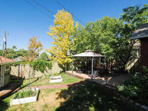 Fenced backyard featuring a deck and a vegetable garden