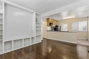 Unfurnished living room featuring dark wood finished floors