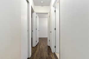 Corridor featuring dark wood finished floors