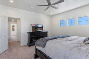 Bedroom with light colored carpet, ceiling fan, and recessed lighting