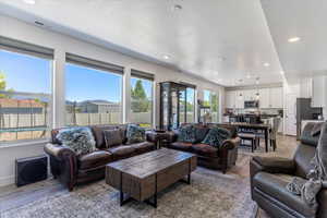 Living room featuring recessed lighting, light wood-type flooring, and a textured ceiling