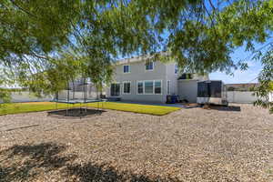 Rear view of property featuring a patio area, a trampoline, and stucco siding