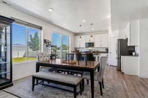 Dining room with light wood-style flooring, a textured ceiling, and recessed lighting