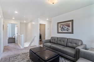 Carpeted living area featuring recessed lighting and a textured ceiling