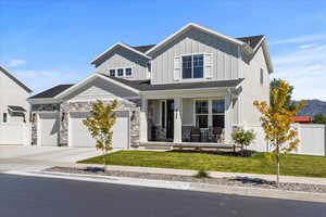 View of front of home featuring a porch, board and batten siding, driveway, roof with shingles, and an attached garage