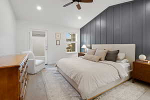 Bedroom featuring light colored carpet, ceiling fan, a decorative wall, recessed lighting, and lofted ceiling
