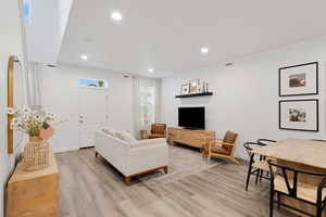 Living room with recessed lighting and light wood-style flooring
