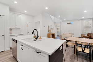 Kitchen with white cabinetry, open floor plan, recessed lighting, and light wood-style floors