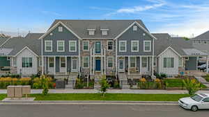 View of front of home with a residential view, board and batten siding, stone siding, and roof with shingles