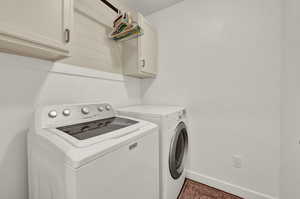 Laundry area featuring cabinet space and separate washer and dryer