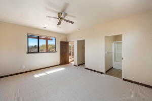 Unfurnished bedroom featuring carpet flooring, a ceiling fan, and ensuite bathroom