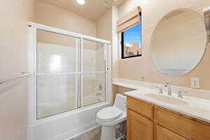 Bathroom with vanity and combined bath / shower with glass door