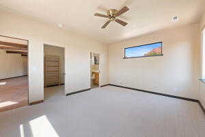 Unfurnished bedroom with carpet flooring, ceiling fan, ensuite bath, and a closet