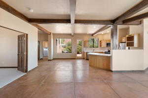 Kitchen featuring beam ceiling, concrete floors, open floor plan, and light countertops