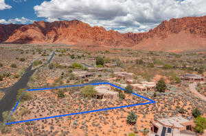 Aerial view of sparsely populated area featuring a mountain backdrop and property boundaries highlighted