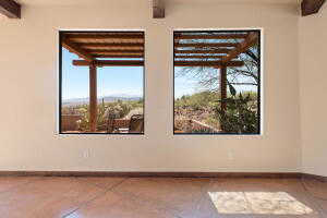Tiled empty room featuring beam ceiling