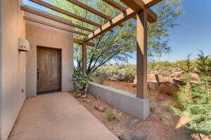 Doorway to property with a pergola and stucco siding