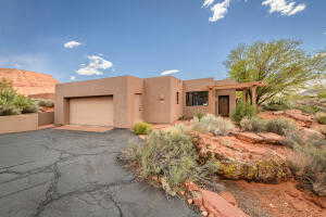 Adobe home with stucco siding, asphalt driveway, and a garage