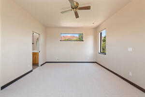 Empty room featuring a ceiling fan and baseboards