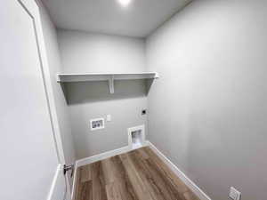 Laundry area with light wood-style floors, hookup for an electric dryer, and hookup for a washing machine