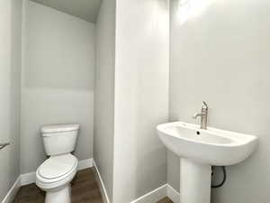 Bathroom with toilet and wood finished floors