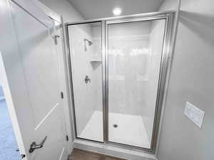 Full bathroom with a shower stall and wood finished floors