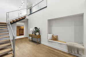 Stairs featuring wood finished floors and a high ceiling