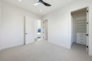 Unfurnished bedroom with light colored carpet and ceiling fan