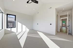 Spare room with vaulted ceiling, light colored carpet, a ceiling fan, and recessed lighting