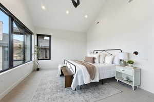 Bedroom with light carpet, lofted ceiling, and ceiling fan