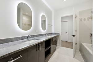 Full bath featuring double vanity,  shower combination, and light tile patterned floors