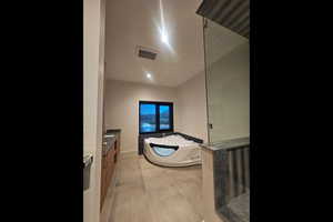 Full bath with vanity, a garden tub, walk in shower, and light tile patterned floors