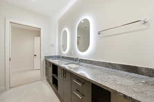 Bathroom featuring double vanity and baseboards