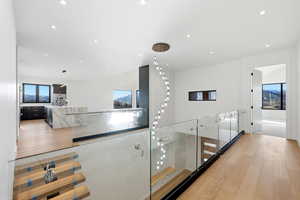 Corridor with light wood-style flooring and recessed lighting