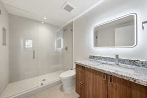 Bathroom with vanity, light tile patterned floors, a shower stall, and recessed lighting