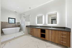 Bathroom with double vanity, a marble finish shower, light marble finish flooring, a freestanding tub, and recessed lighting