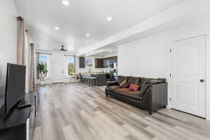 Living room with recessed lighting, light wood-style floors, and ceiling fan