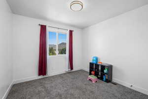 Carpeted empty room featuring baseboards