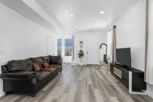 Living area with light wood-style flooring and recessed lighting