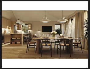 Dining area with light wood finished floors and vaulted ceiling